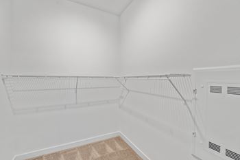 A white wall with a shelf and a vent.